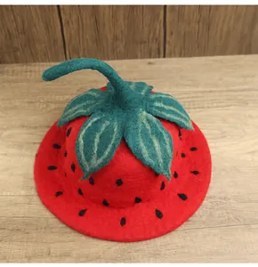 Dettaglio della trama del cappello a fragola in feltro rosso su fondo di legno