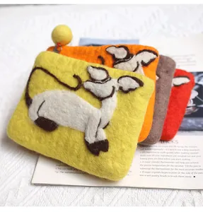 Detailed texture of handmade wool felt coin purses with cute sheep patterns and zippers