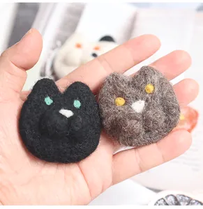 Macro shot of handmade wool felt cat head pins showing soft texture and 3D details
