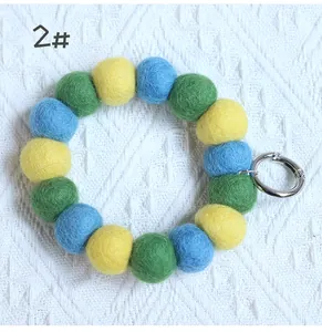 Macro detail of colorful handmade wool felt balls bracelet keychain with metal spring ring