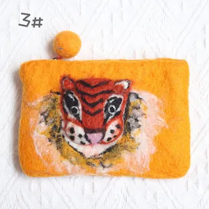 Detail of handmade wool felt coin purse featuring a 3D orange tiger face design