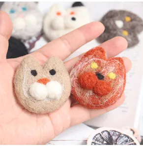 Close-up of handmade wool felt cat patches showing fiber texture and cute animal details