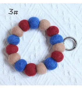 Detail of wool felt ball keychain with colorful beads and silver spring ring buckle