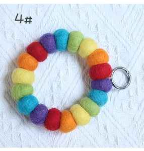 Detailed macro view of colorful felt ball keychain ring with silver metal clip attachment