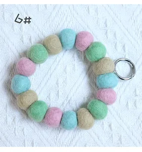 Close-up of colorful wool felt ball keychain loop with silver metal spring ring