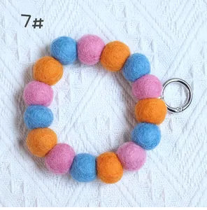 Close-up of colorful wool felt ball keychain loop with pink orange and blue spheres