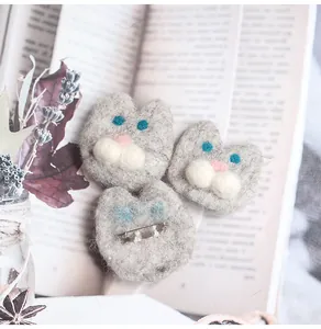 Detail view of handmade wool felt cat brooches with front and metal pin back fasteners
