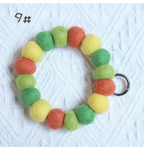 Macro detail of colorful handmade wool felt ball ring keychain with silver spring clasp