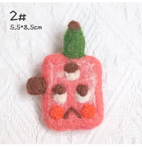 Detail showing pink handmade wool felt brooch with three eyes and 5.5x8.5cm dimensions