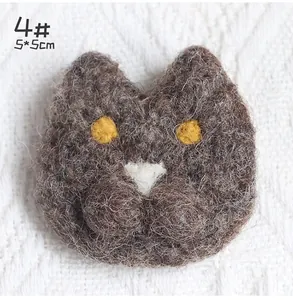 Close-up of handmade 5x5cm wool felt cat head brooch with detailed fiber texture
