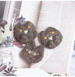 Detail of handmade cat felt brooch with metal pin back and soft wool texture