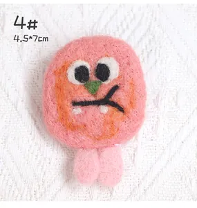 Close-up of pink handmade felt monster brooch showing 4.5 by 7cm dimensions and texture