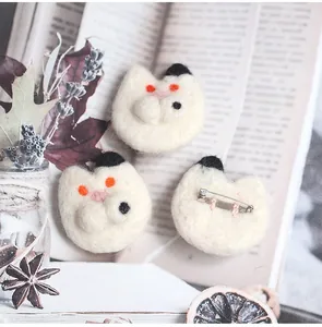 Detail view of handmade wool felt cat brooches with metal safety pin fastener