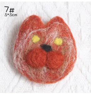 Close-up of handmade 5x5cm orange wool felt cat brooch pin with plush texture details