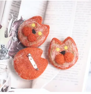 Detail of wool felt fox brooch with orange fiber texture and metal safety pin clasp