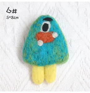 Detail of a handmade blue wool felt monster brooch with 5x8cm size label and single eye