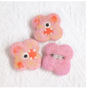 Detail showing back silver metal pins on cute handmade pink monster wool felt brooches