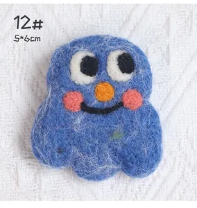 Macro shot of 5x6cm handmade blue wool felt monster brooch with needle felted texture