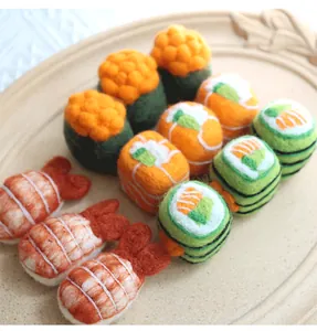 Macro shot of three detailed handmade wool felt sushi charms on an embossed white tray