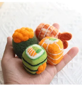 Handmade wool felt sushi miniatures held in hand showing delicate texture and size