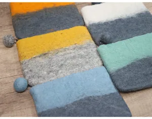 Macro shot of colorful wool felt wallets with zipper details on a wooden background