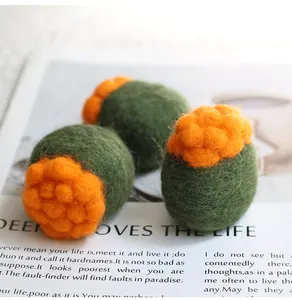 Macro view of handmade wool felt succulent accessories with orange flower details