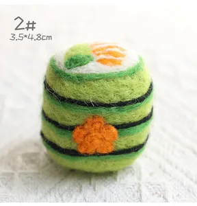 Close-up of handmade wool felt sushi roll charm with orange flower detail, 3.5x4.8cm
