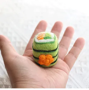 Detailed close-up of a mini handmade felt sushi roll keychain accessory in hand