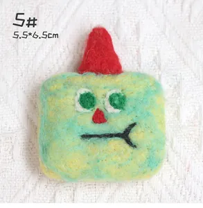 Detail of wool felt brooch featuring a red hat monster with 5.5*6.5cm dimensions