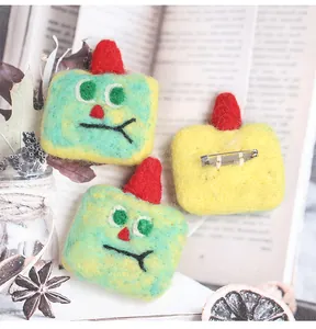 Detail of handmade wool felt brooches with red hats and silver metal safety pin backs