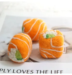 Detailed macro view of three handmade wool felt salmon sushi rolls for DIY crafts