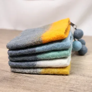 Handmade wool felt coin purse with colorful patchwork design and fuzzy pom pom zipper puller
