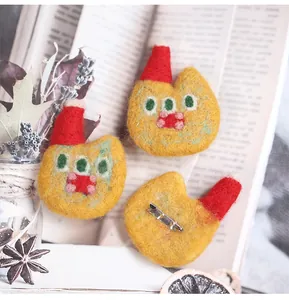 Detail of handmade wool felt brooches with red Christmas hats and fluffy texture