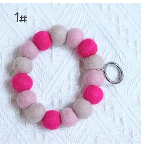 Llavero de pulsera con bolas de fieltro rosa y gris y anilla metálica plateada mate