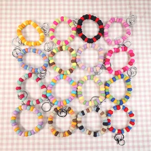 Detailed grid of sixteen colorful wool felt ball keychain bracelets with metal rings