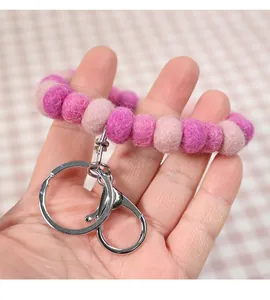 Macro shot of pink wool felt balls keychain wristlet with a silver metal clasp