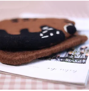 Macro detail of cute brown bear wool felt coaster with thick texture and fiber details