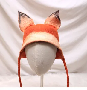 Detailed view of handmade wool felt fox hat with pointed ears and braided tassels