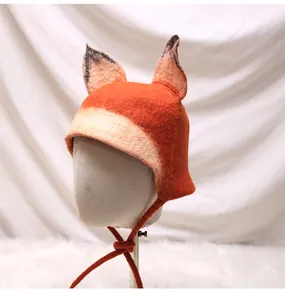 Detailed texture of handmade orange wool felt fox hat with long chin straps and soft ear flaps