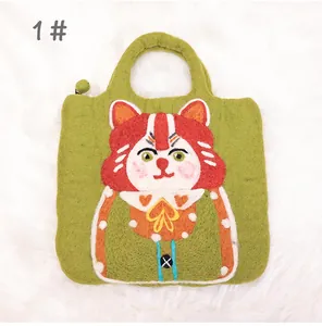Detail of green wool felt cat handbag with a zipper closure and colorful charms