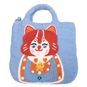 Sky blue felt handbag featuring a cute cartoon cat pattern with a fuzzy blue ball accent