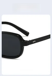 Detail view of black square sunglasses with silver rivets on high-quality frames