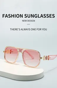 Close-up of rose embossed logo on gold metal frame and gradient pink lenses of sunglasses