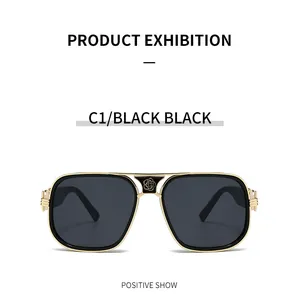 Detail of golden floral relief on oversized metal sunglasses with black lenses
