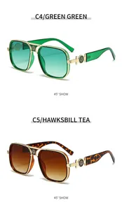 Detail of oversized pilot sunglasses with floral gold metal accents in green and amber