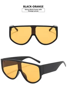Detail view of oversized shield sunglasses featuring bright black frame and orange lenses