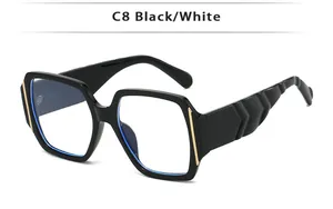 Detail of glossy black square frame sunglasses with golden metal accents and blue light filter