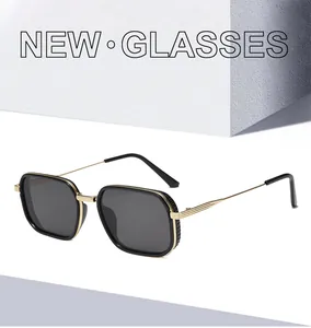 Close-up of square black frame sunglasses with golden metal temples and elegant gold trim