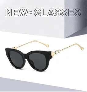 Détail de lunettes de soleil œil de chat avec branches en cœur doré et strass étincelants
