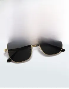 Détail de lunettes de soleil carrées en métal avec monture dorée et verres foncés